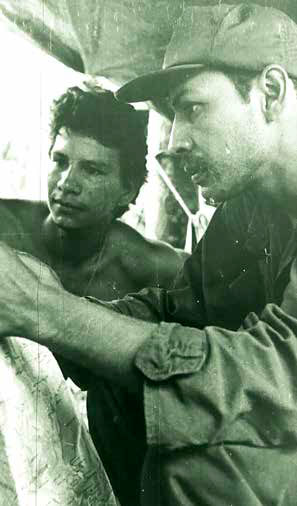 Carlos Duarte, en el puesto de mando La Calera, estudiandoun mapa operativo. al fondo Silvio Áreas, “Kuenty”, quien resultó herido en el lugar, falleciendo el 20 de julio de 1979 en hospital de Liberia, Costa Rica.