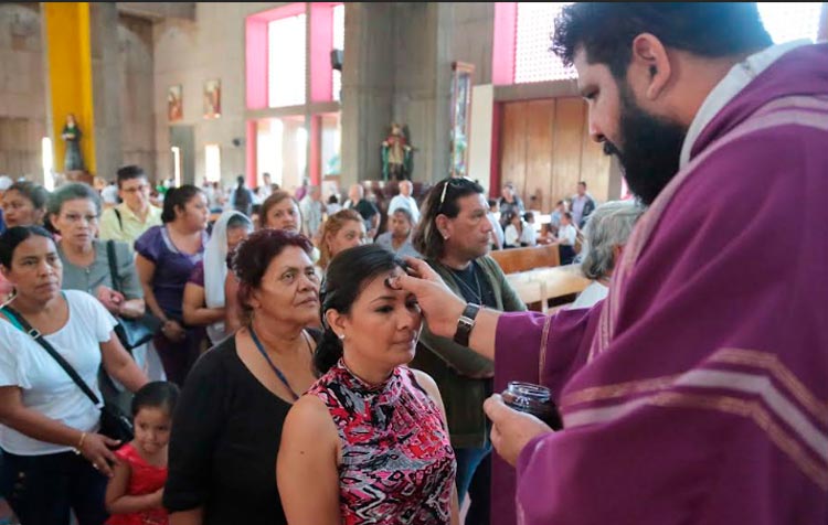 Foto de Sacerdote imponiendo la ceniza a feligreses